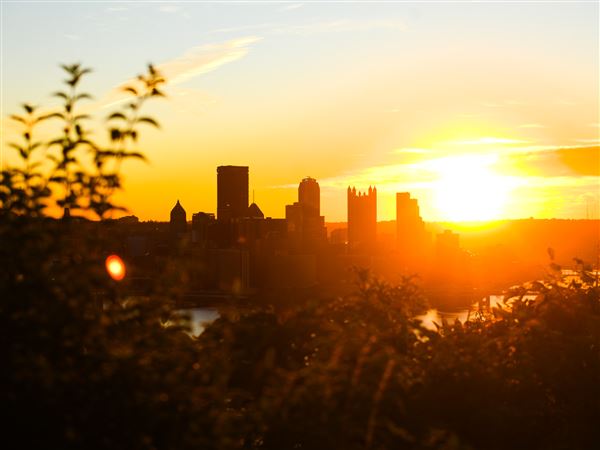 The sun rises behind the downtown skyline, as seen from the West End Overlook on Tuesday, Oct. 28, 2025.