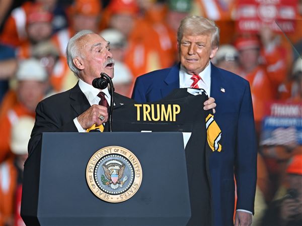 Pittsburgh Steelers great Rocky Bleier gives President Donald Trump a Steelers shirt during the announcement of a “planned partnership” between U.S. Steel and Nippon Steel at U.S. Steel’s Irvin Works in West Mifflin on May 30. Pittsburgh can benefit from the Trump administration while still holding it at arm’s length, writes Brandon McGinley.