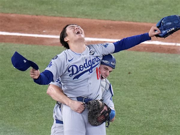 Los Angeles Dodgers pitcher Yoshinobu Yamamoto (18) celebrates with teammate Will Smith after the team defeated the Toronto Blue Jays in Game 7 of baseball's World Series, Sunday, Nov. 2, 2025, in Toronto.