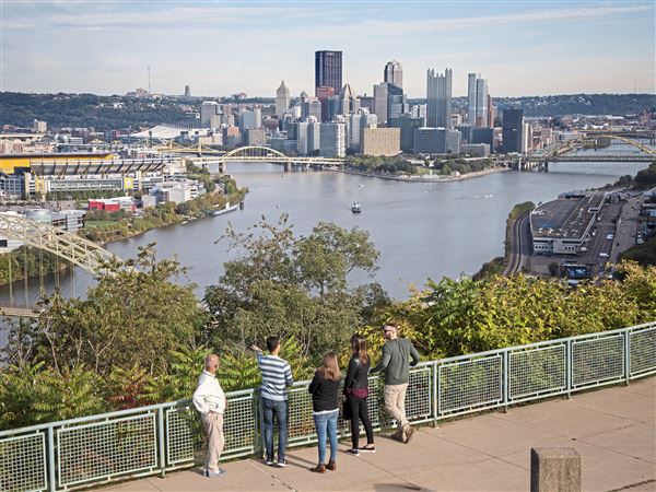 Site seers gaze over the three rivers toward the Downtown Pittsburgh skyline, Sunday, Oct. 13, 2019, at the West End-Elliott Overlook in Elliott.