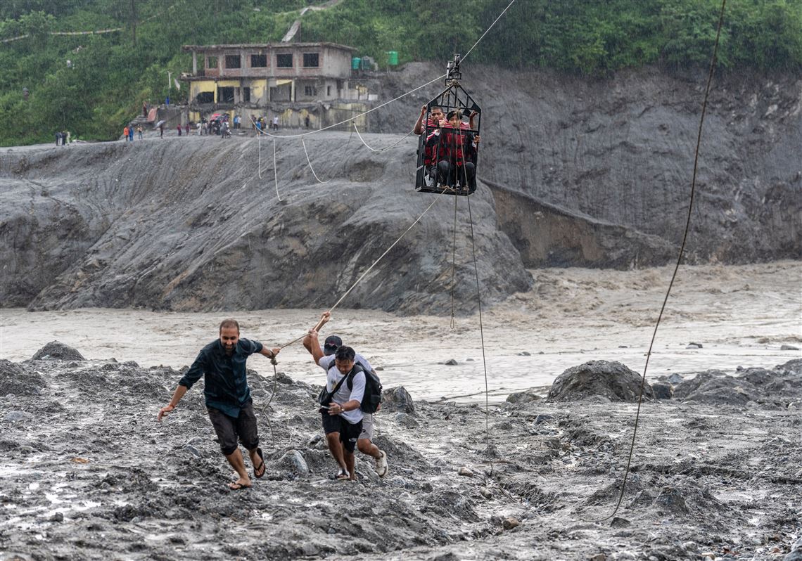 Trading food for medicine and crossing the river by zip line are part of life in Nepal flood zone